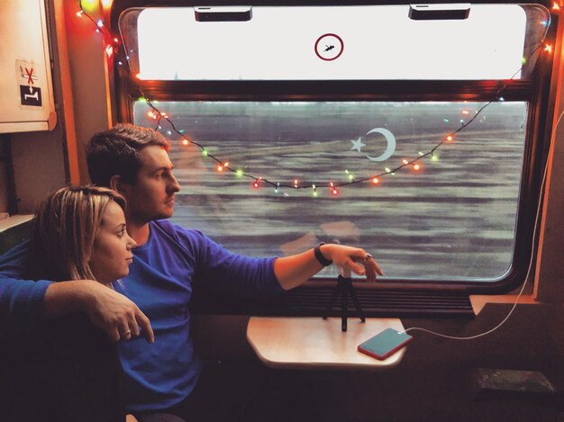 A split-screen image showing two different Nintendo Switch games being played on a train, one a fast-paced action game and the other a relaxing puzzle game, highlighting the versatility of the console for travel.