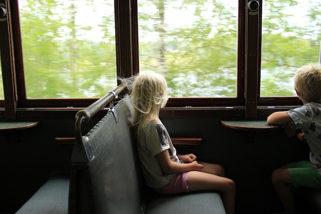 A person relaxing in a comfortable chair on a train, engrossed in playing a colorful puzzle game on their Nintendo Switch, with a serene landscape visible through the window.