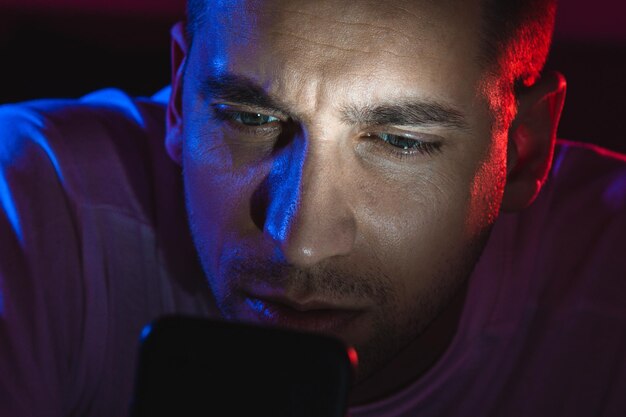 A close-up of a gamer intensely focused on their monitor, their face illuminated by the screen. The background is blurred, emphasizing the concentration.