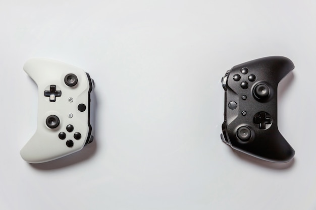 Image of a close-up comparison between the Xbox Elite Wireless Controller Series 2 and the Sony DualSense controller, highlighting their unique features like the interchangeable parts on the Xbox Elite and the adaptive triggers on the DualSense. Each controller is positioned to showcase its design and ergonomic features.