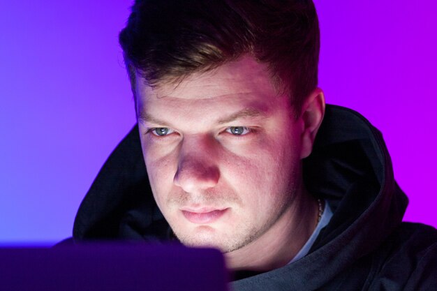 A close-up shot of a gamer's determined face, illuminated by the screen, showing intense focus and concentration. The background is blurred to emphasize the player's mental engagement in the game.