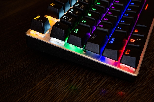 A close-up shot of high-end gaming peripherals including a mechanical keyboard with customizable RGB lighting, a gaming mouse with multiple buttons, and a high-quality gaming headset with clear sound isolation, all placed on a gaming desk with a clean and organized setup.
