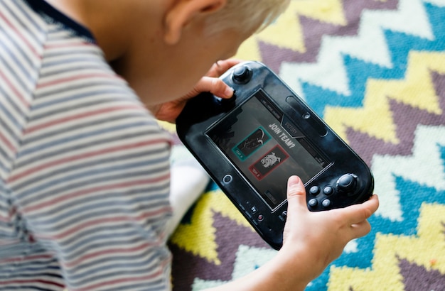 A close-up shot of a Nintendo Switch console with two Joy-Con controllers attached. The screen displays a colorful and engaging game suitable for children.