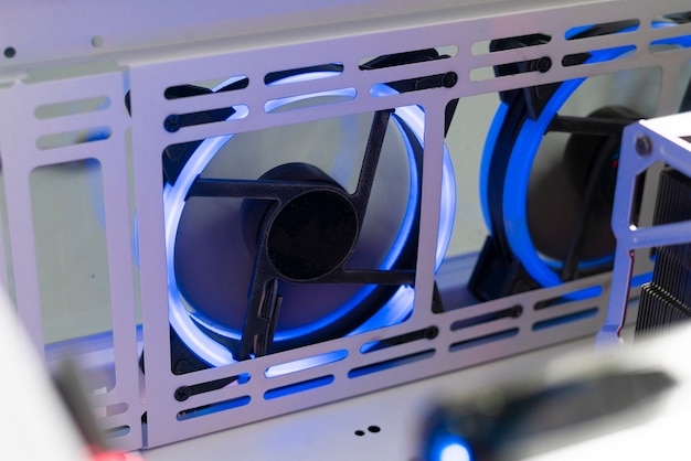 A close-up photo of the internal cooling system of a PlayStation 5, highlighting the large fan and heat sink design. Good lighting to show details.