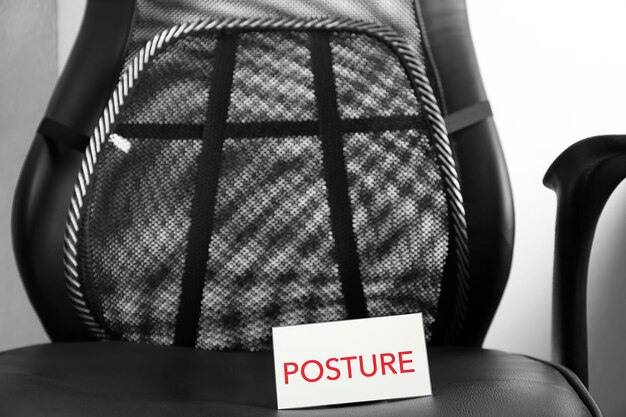 A close-up shot of the adjustable lumbar support feature of a gaming chair. The mechanism is visible, showcasing how it can be adjusted to fit the user's lower back perfectly. The material of the chair is high-quality leather, and the stitching is precise and durable.