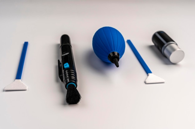 Close-up of various cleaning tools for PC components, including a can of compressed air, anti-static brush, microfiber cloths, and isopropyl alcohol. The tools are neatly arranged on a clean surface.